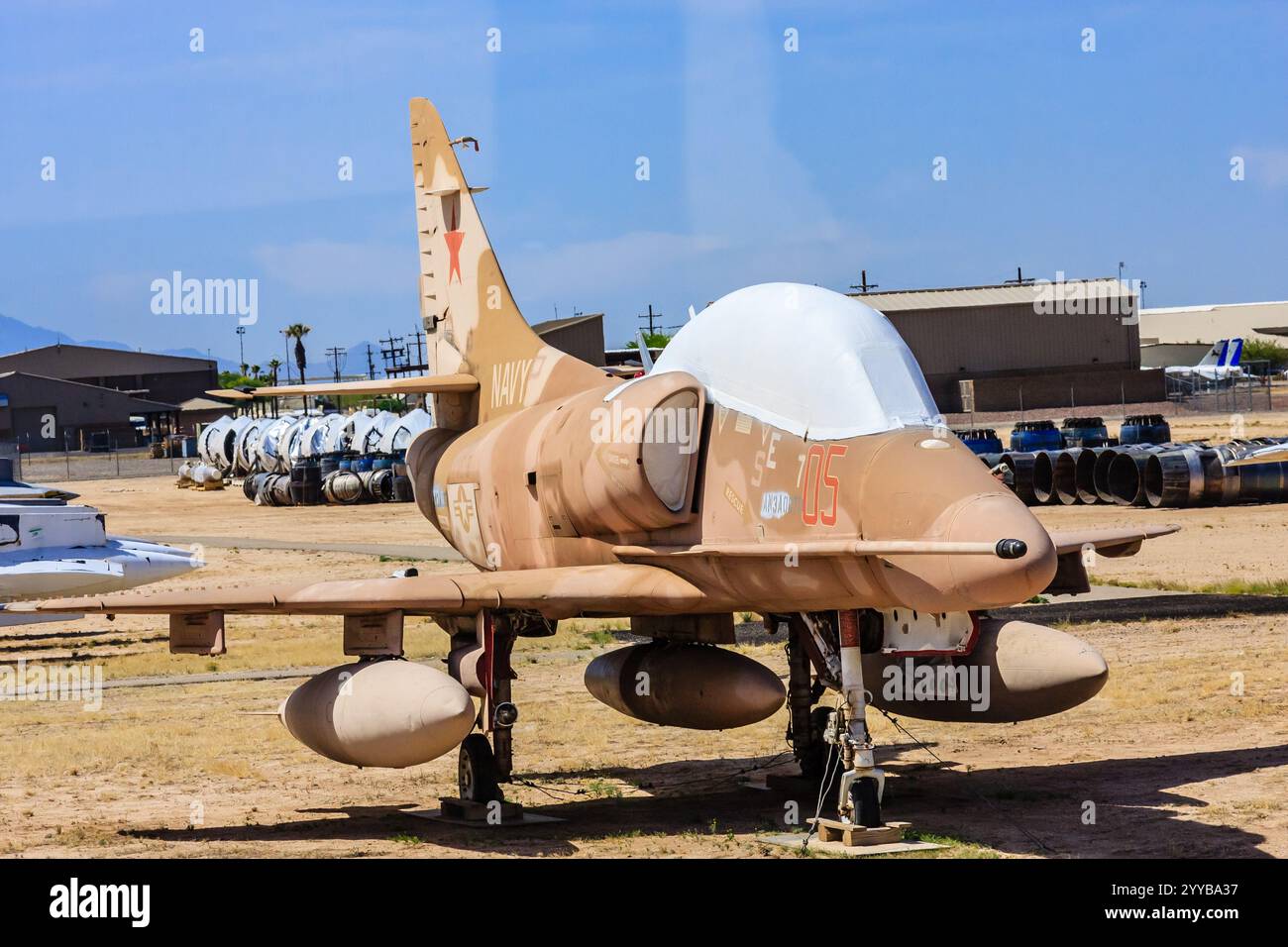 Un jet da caccia bianco e abbronzato è parcheggiato sulla pista. L'aereo è vecchio e ha una croce rossa sulla coda. La scena è tranquilla e tranquilla, senza nessun'altra Foto Stock