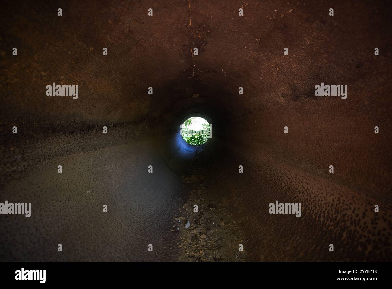 Vecchio tubo in acciaio arrugginito con estremità luminosa, vista prospettica del tunnel grunge Foto Stock