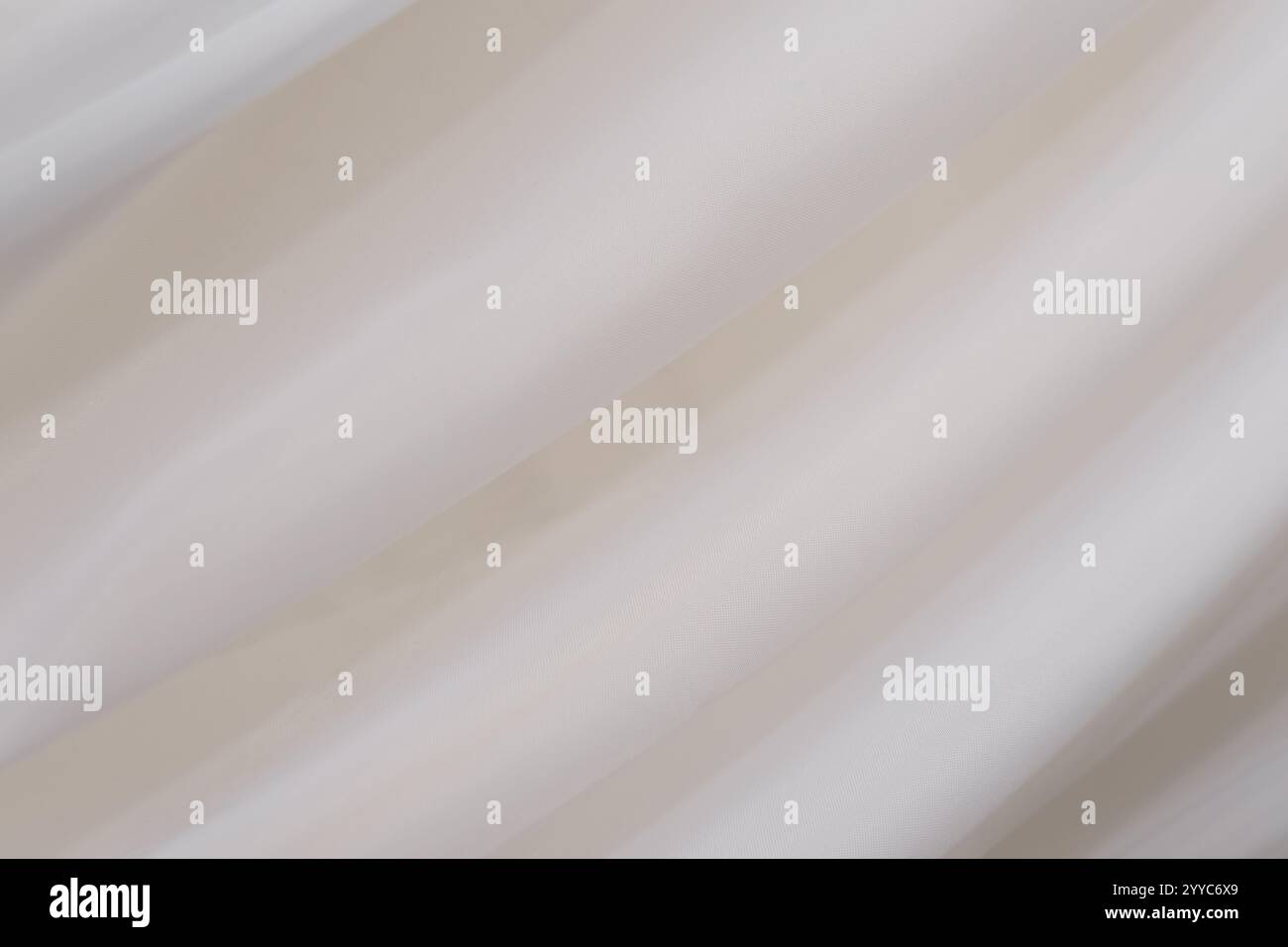 Una cascata di tessuto morbido si presenta graziosamente in tonalità neutre, creando un'atmosfera serena in una stanza ben illuminata. Le pieghe morbide migliorano il design minimalista, Foto Stock