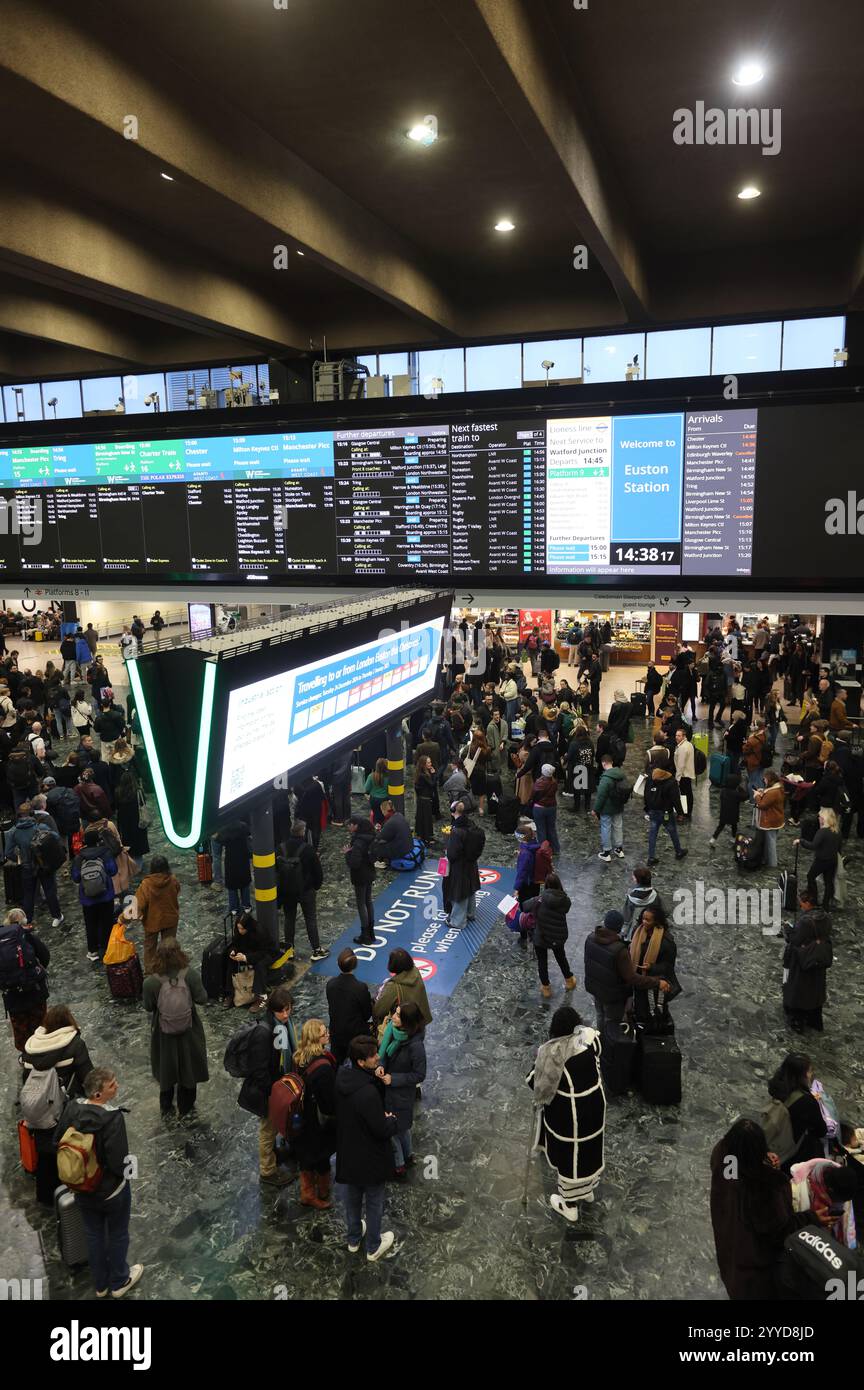 Il grande schermo viene utilizzato per le partenze di nuovo alla stazione di Euston mentre la vacanza natalizia si avvia, a nord di Londra, Regno Unito Foto Stock