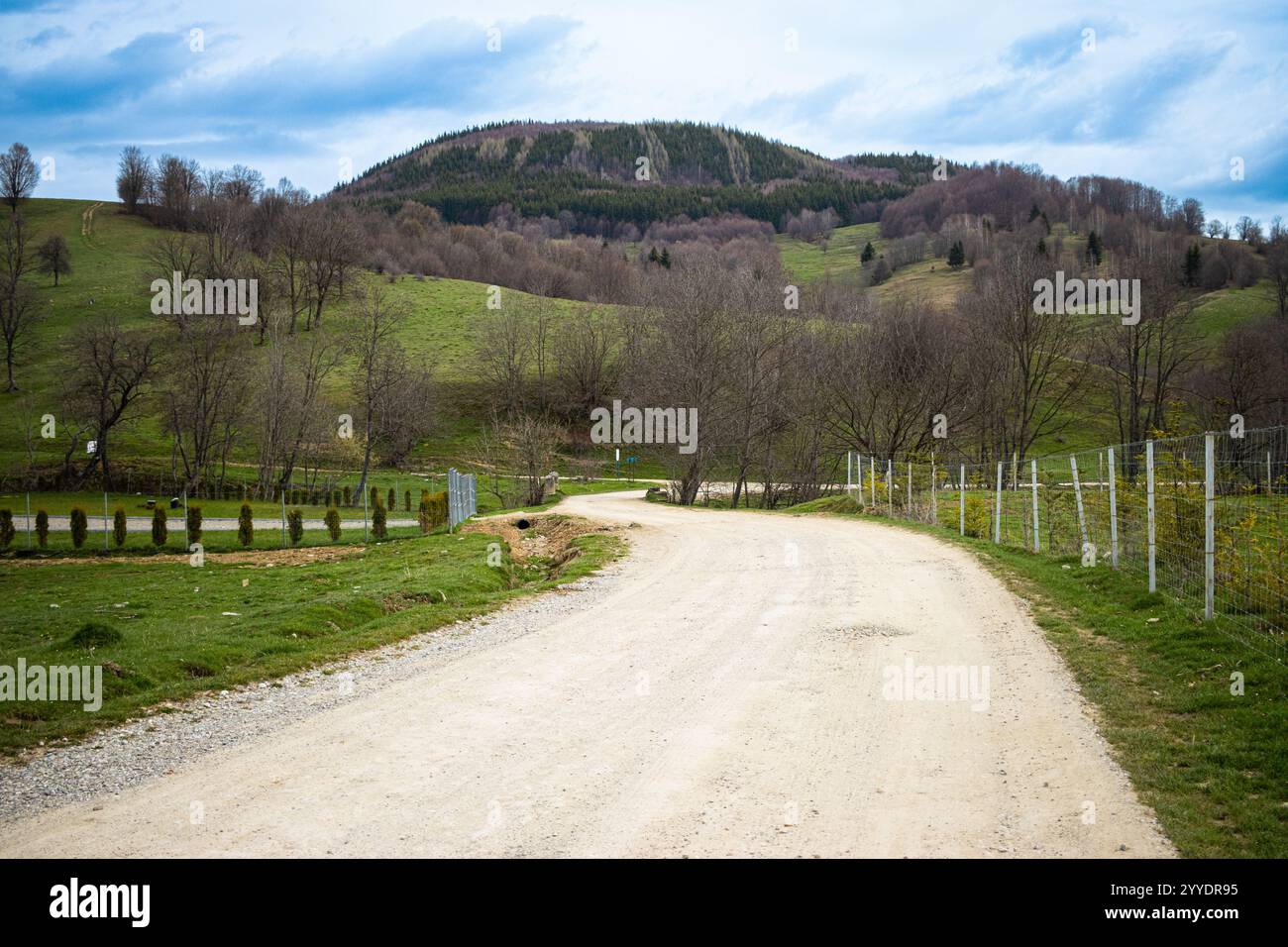 Strada non asfaltata che passa attraverso i villaggi in Romania. Strada sterrata nella Romania rurale Foto Stock