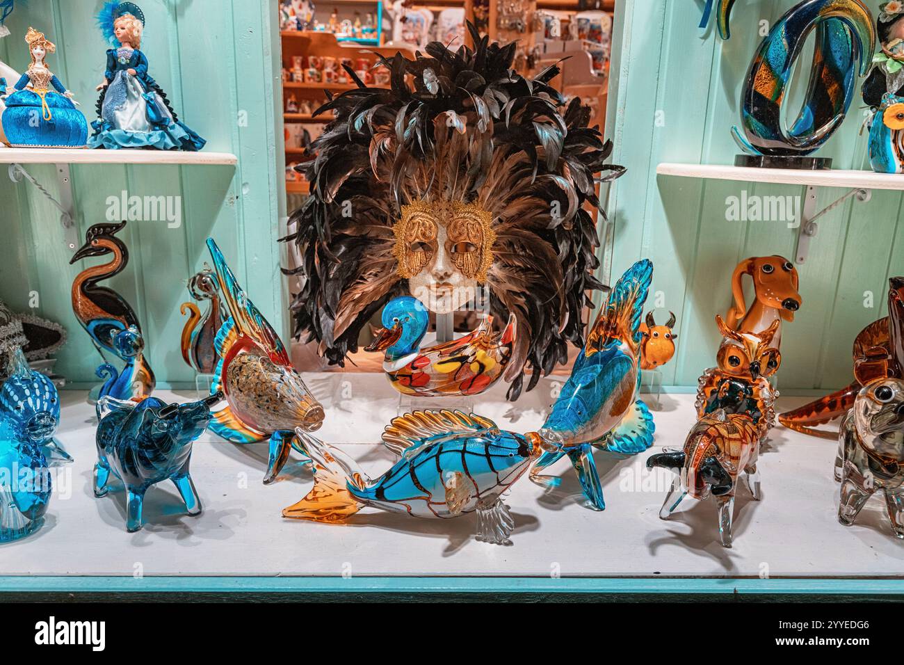 25 ottobre 2024, Cattaro, Montenegro: Le colorate statuette di animali in vetro di Murano e una maschera di carnevale veneziana sono esposte in una vetrina che mostra Ita Foto Stock