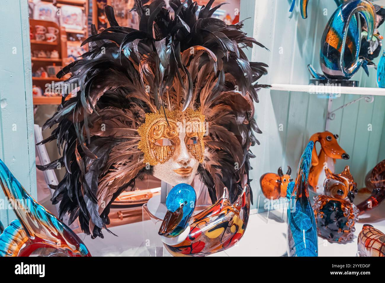 25 ottobre 2024, Cattaro, Montenegro: Le colorate statuette di animali in vetro di Murano e una maschera di carnevale veneziana sono esposte in una vetrina che mostra Ita Foto Stock