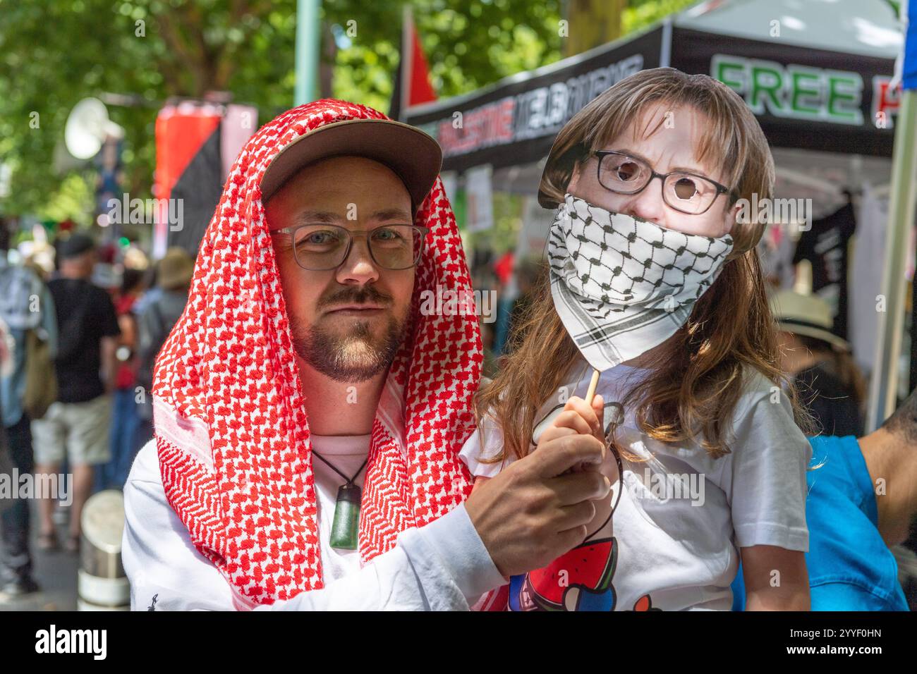 Simon un manifestante ha una maschera del Premier di Stato??Jacinta Allan indossa un keffiyeh che ha fatto sul volto di sua figlia prima che marciassero per le strade, protestando contro i governi dello Stato hanno proposto leggi di protesta mentre sostenevano la fine della guerra nei diritti palestinesi. Una protesta pro-Palestina ebbe luogo a Melbourne, Victoria, mentre i manifestanti espressero la loro opposizione alle proposte di leggi statali che vietavano le maschere ai raduni pubblici. I manifestanti, molti indossano rivestimenti facciali, hanno evidenziato l'impatto che tali leggi potrebbero avere sulla libertà di espressione e sul dissenso pubblico pur continuando a sostenere lo jus Foto Stock