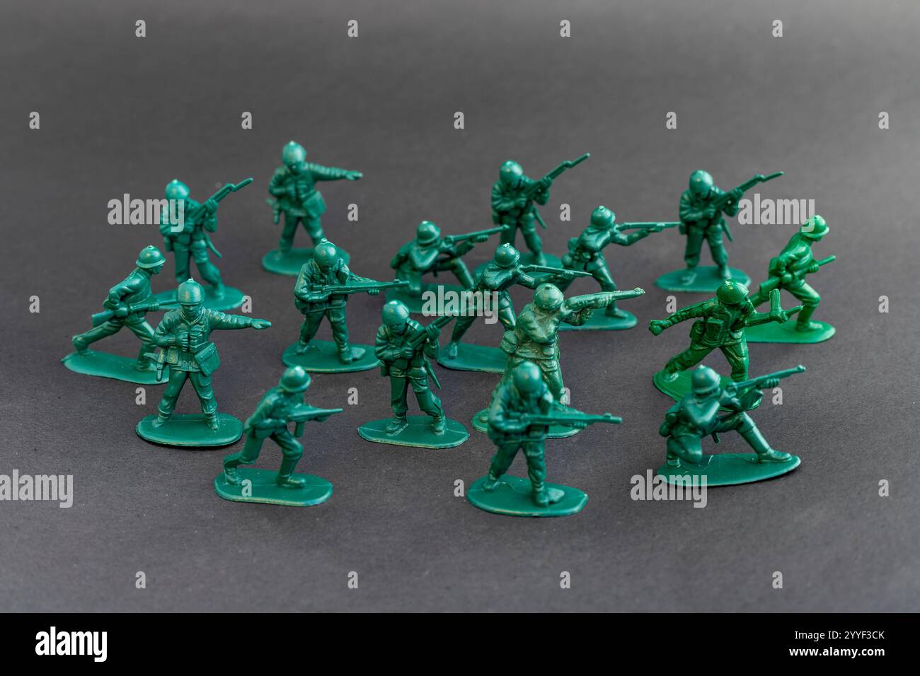 I soldati verdi giocattolo pongono formazione per attaccare il nemico. Concetto di gioco di guerra. Foto Stock