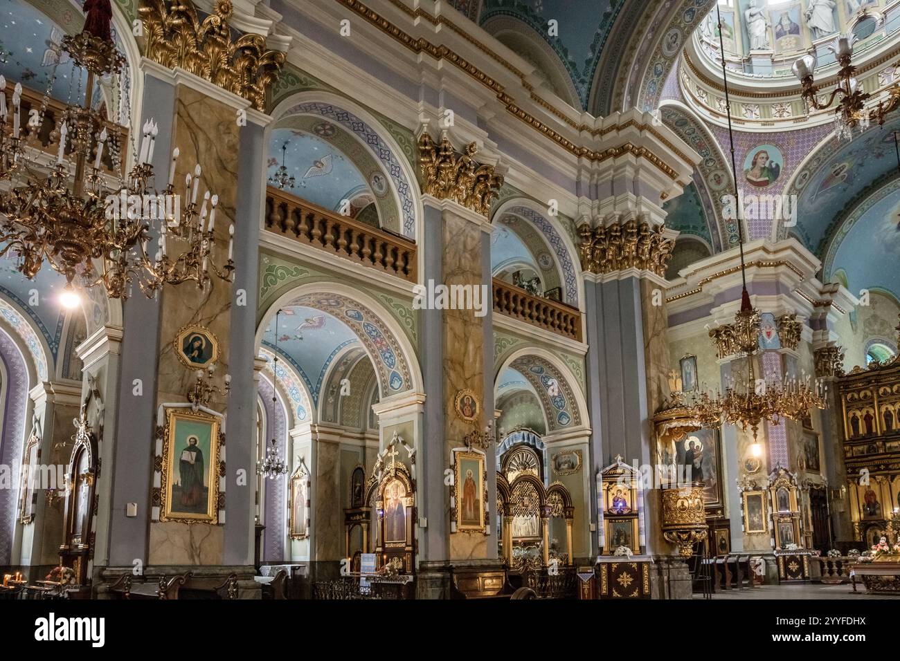 L'interno di una chiesa è decorato con colori oro e blu. Le pareti sono adornate con dipinti e il soffitto è alto e ornato. L'atmosfera Foto Stock