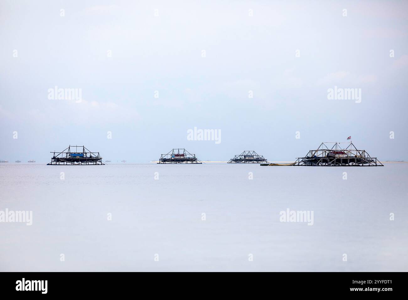 Tradizionali piattaforme di pesca in legno per la pesca notturna con un piccolo cottage di pescatori, in mezzo a un mare, l'isola di sulawesi, indonesia Foto Stock