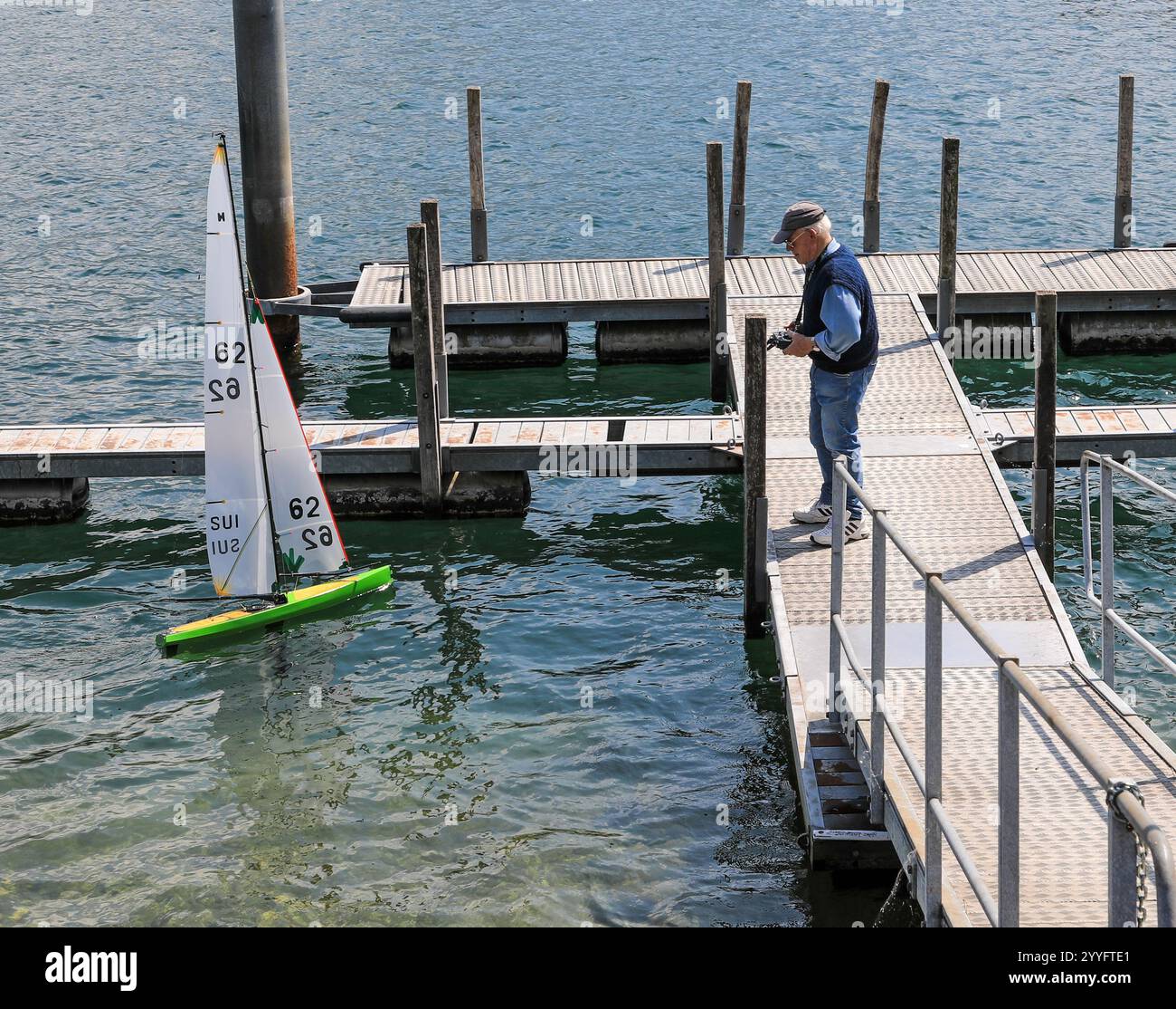 Un uomo anziano che naviga su un modellino telecomandato sul Lago maggiore, Locarno, Svizzera, Europa Foto Stock
