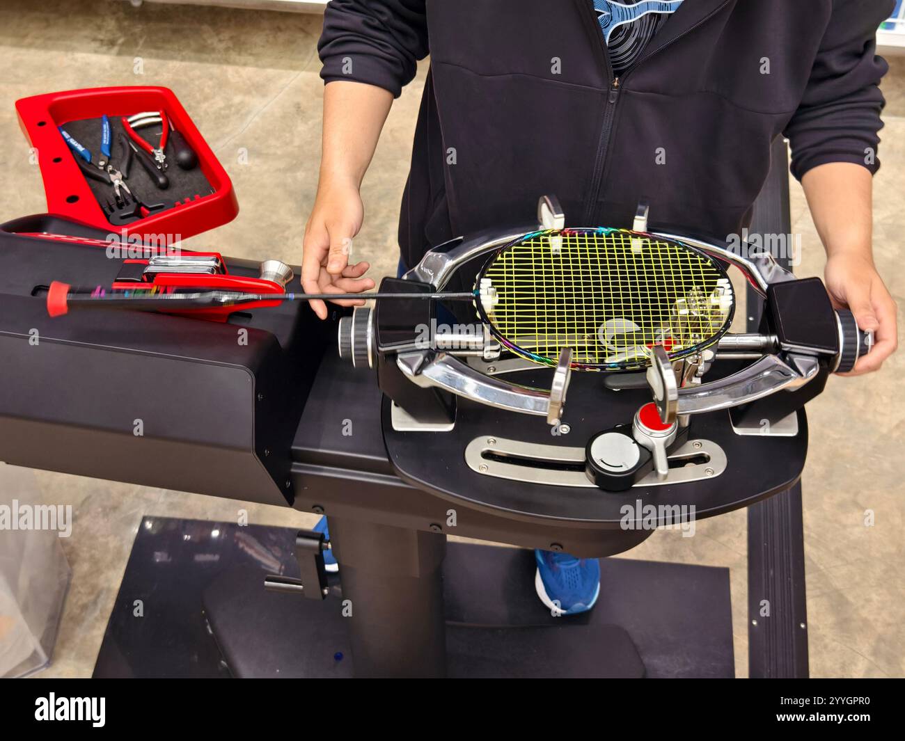 Indossa una racchetta da badminton su una macchina per stringere a racchetta. Foto Stock