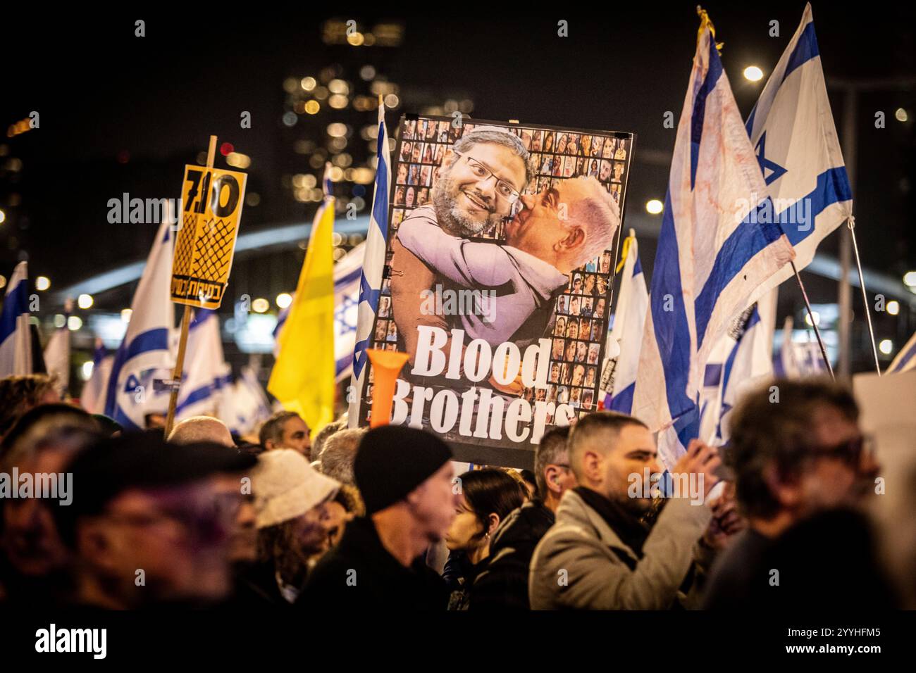 I manifestanti sono sotto un cartello che mostra il primo ministro israeliano Benjamin Netanyahu e il ministro della sicurezza nazionale Itamar Ben Gvir durante una protesta a Tel Aviv sabato 21 dicembre 2024. Sabato, migliaia di persone sono scese per le strade di Israele chiedendo all'attuale governo guidato dal primo ministro Benjamin Netanyahu di raggiungere un accordo con Hamas. Foto di Eyal Warshavsky. Foto Stock