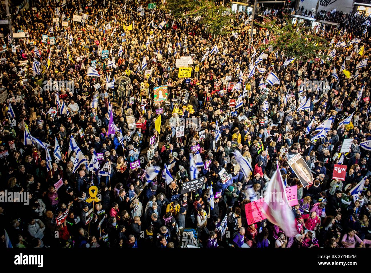 I manifestanti cantano e ondate cartelloni durante una protesta a Tel Aviv sabato 21 dicembre 2024. Sabato, migliaia di persone sono scese per le strade di Israele chiedendo all'attuale governo guidato dal primo ministro Benjamin Netanyahu di raggiungere un accordo con Hamas. Foto di Eyal Warshavsky. Foto Stock