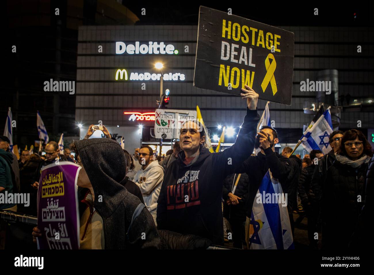 Una donna regge un cartello che chiede un accordo per il rilascio di ostaggi durante una protesta a Tel Aviv sabato 21 dicembre 2024. Sabato, migliaia di persone sono scese per le strade di Israele chiedendo all'attuale governo guidato dal primo ministro Benjamin Netanyahu di raggiungere un accordo con Hamas. Foto di Eyal Warshavsky. Foto Stock