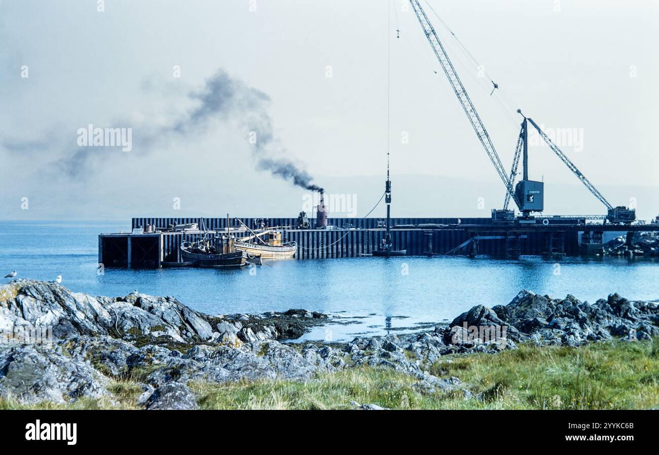 Foto storica di barche da pesca ormeggiate al molo con gru a Campbeltown, Argyll, Scozia, Regno Unito negli anni '1960 Foto Stock