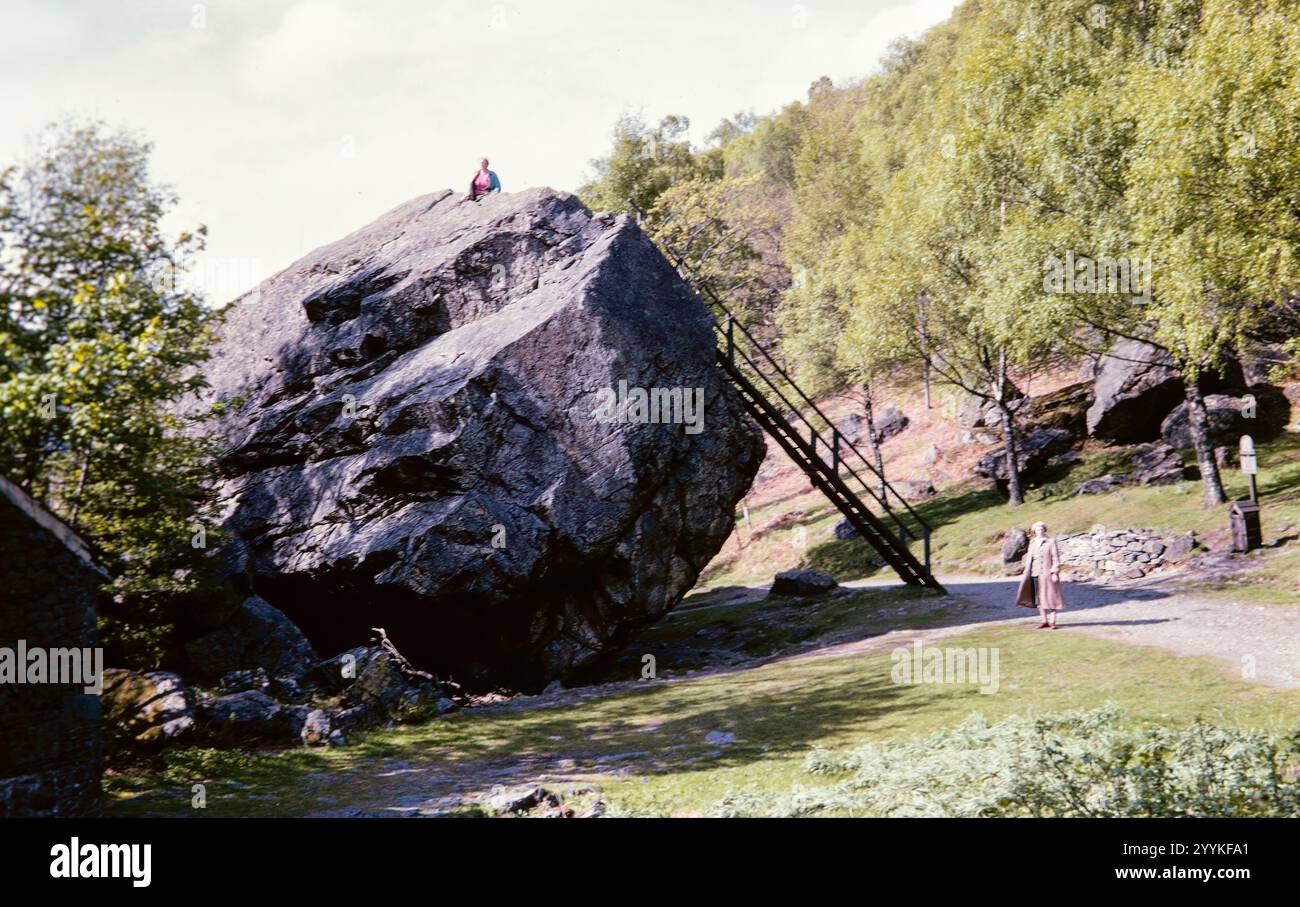 Foto storica di donne che visitano la Bowder Stone negli anni '1960, Lake District, Cumbria, Inghilterra, Regno Unito Foto Stock