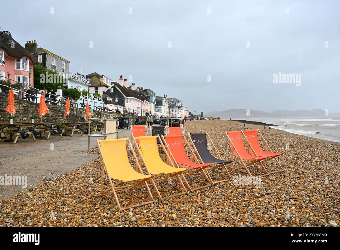 Lyme Regis Dorset UK weekend invernale sotto la pioggia sulla spiaggia con sdraio vuote Foto Stock