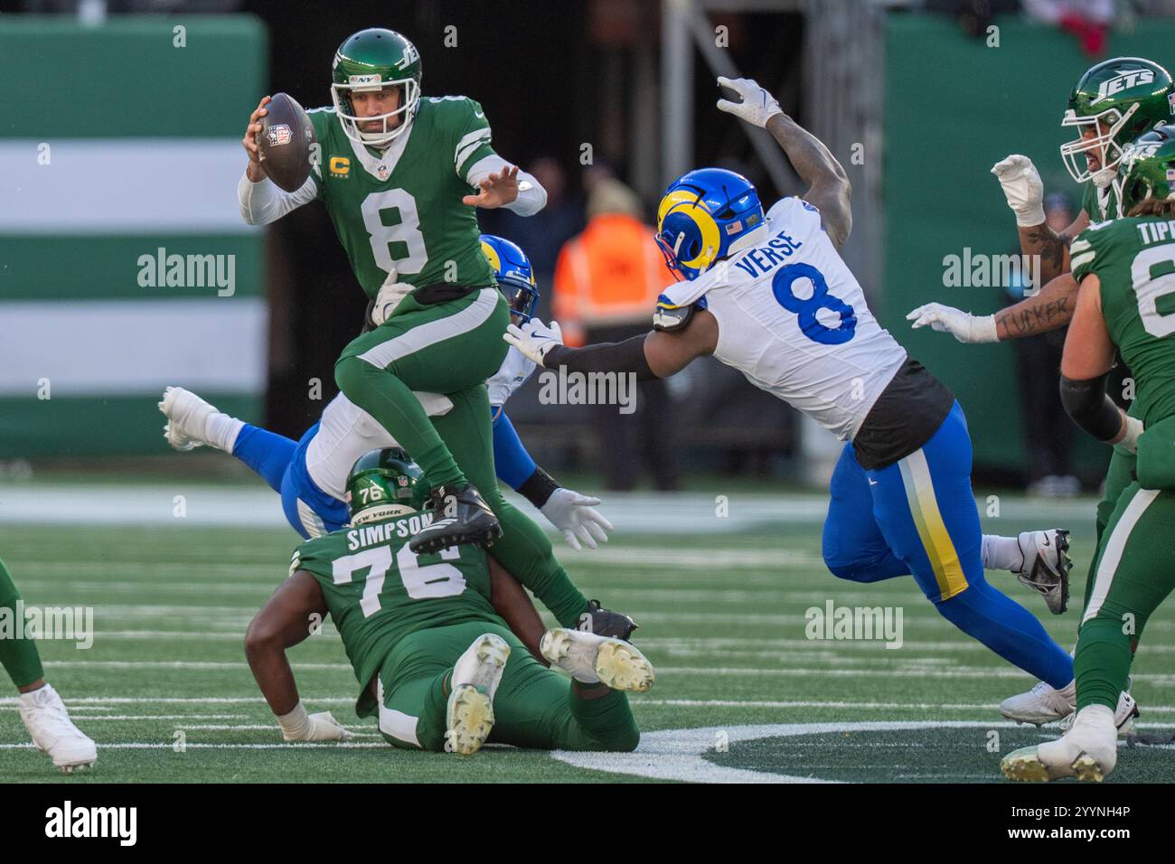 Il quarterback dei New York Jets Aaron Rodgers (8) salta sopra l'offensive lineman John Simpson (76) mentre cerca di allontanarsi dal linebacker dei Los Angeles Rams Jared Verse (8) durante la partita di football della NFL, domenica 22 dicembre 2024, a East Rutherford. (Christopher Szagola/Cal Sport Media) (immagine di credito: © Christopher Szagola/Cal Sport Media) Foto Stock