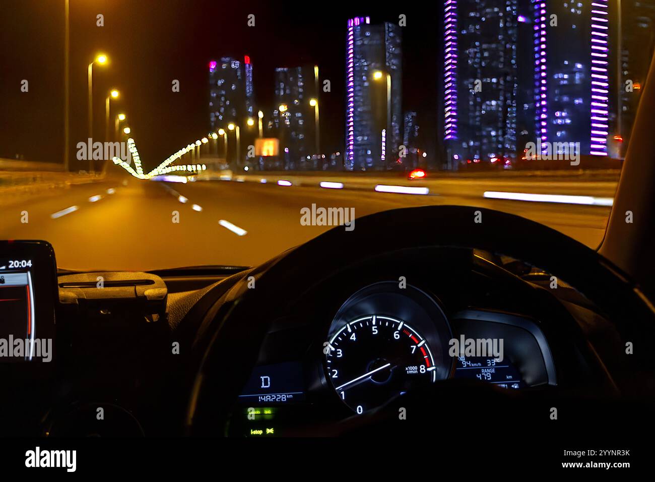 Vista di un'autostrada in una città notturna attraverso il parabrezza di un'auto in movimento Foto Stock