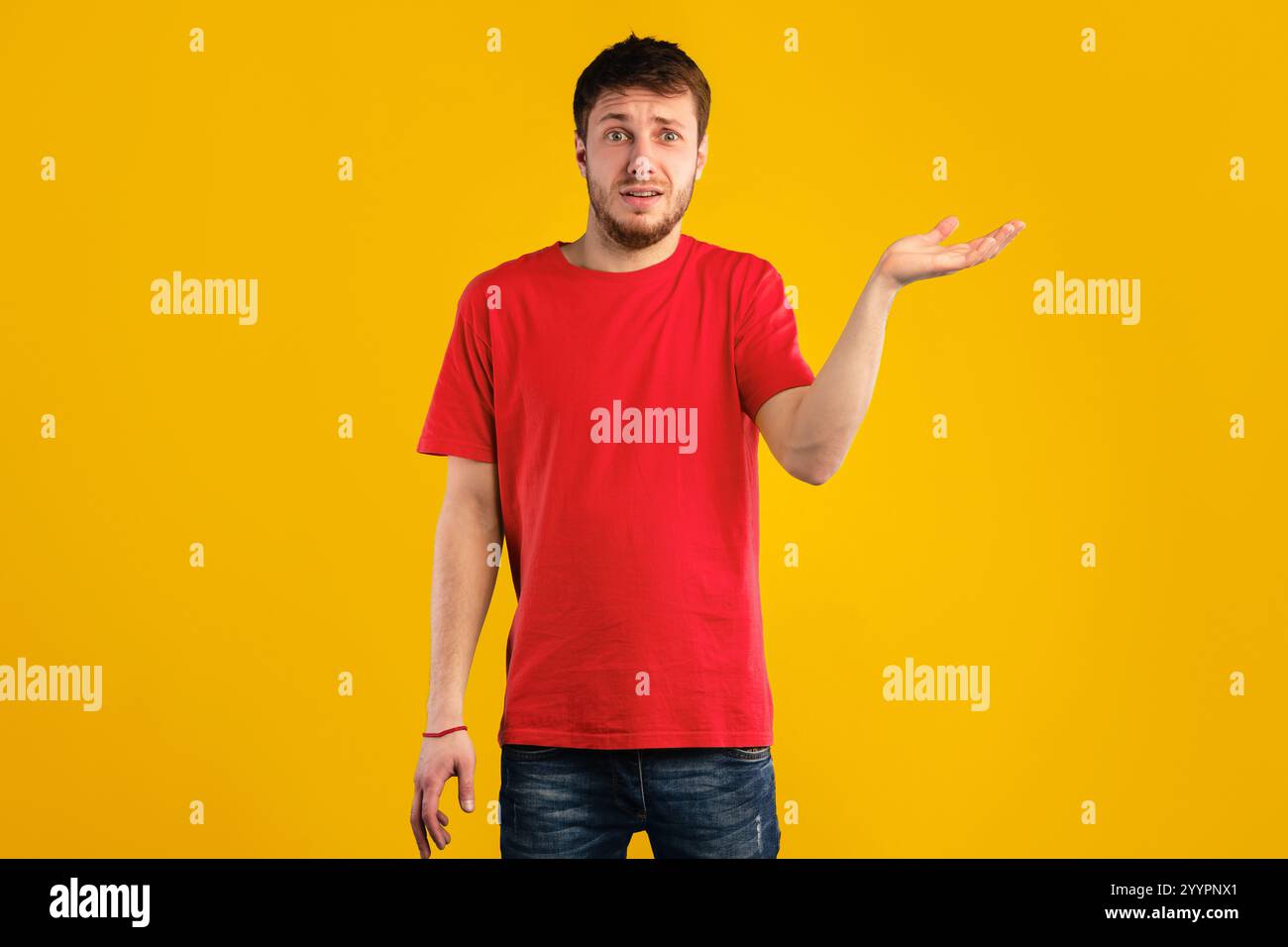 Confuso e perplesso giovane uomo che si è sgombrato in studio Foto Stock