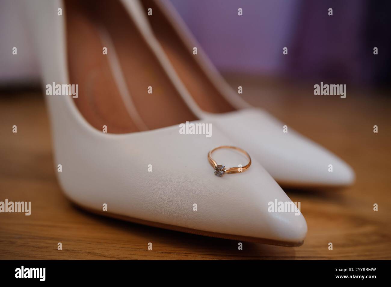 Eleganti scarpe da sposa con un anello di fidanzamento scintillante. Foto Stock