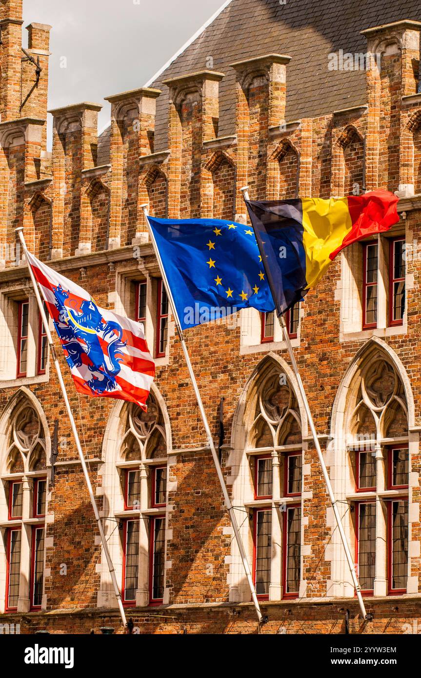 Bandiere tricolore di Bruges, Euro e Belgio in costruzione a Bruges, Fiandre occidentali, Belgio.pali di bandiera Foto Stock
