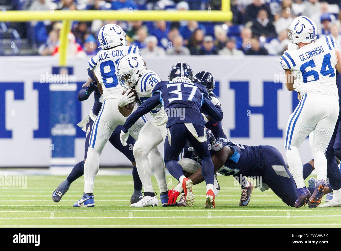Indianapolis, Indiana, Stati Uniti. 22 dicembre 2024. Il running back degli Indianapolis Colts Jonathan Taylor (28) corre con la palla come la safety dei Tennessee Titans Amani Hooker (37) insegue durante la gara NFL al Lucas Oil Stadium di Indianapolis, Indiana. John Mersits/CSM/Alamy Live News Foto Stock