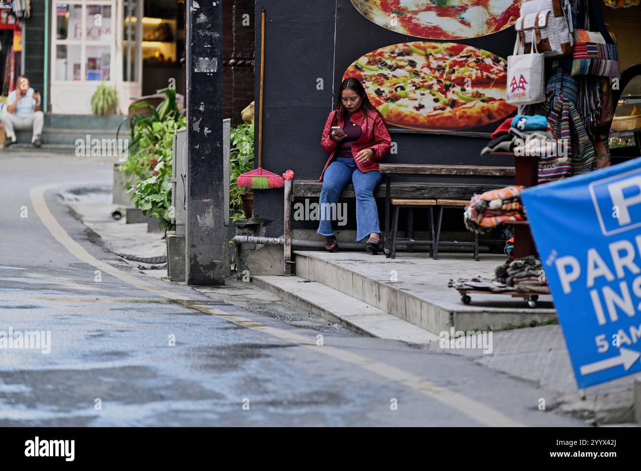 Una donna nepalese che controlla il suo telefono a Thamel, Kathmandu, Nepal. Foto Stock