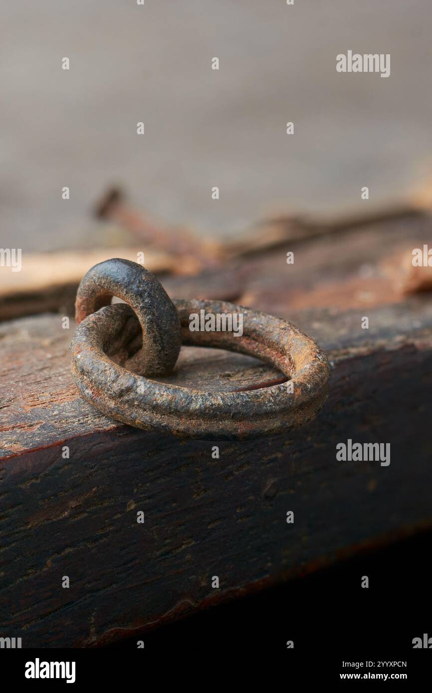 primo piano del vecchio anello metallico arrugginito utilizzato per appendere la cornice alla parete in modo sicuro, messa a fuoco morbida con sfondo sfocato e spazio di copia Foto Stock
