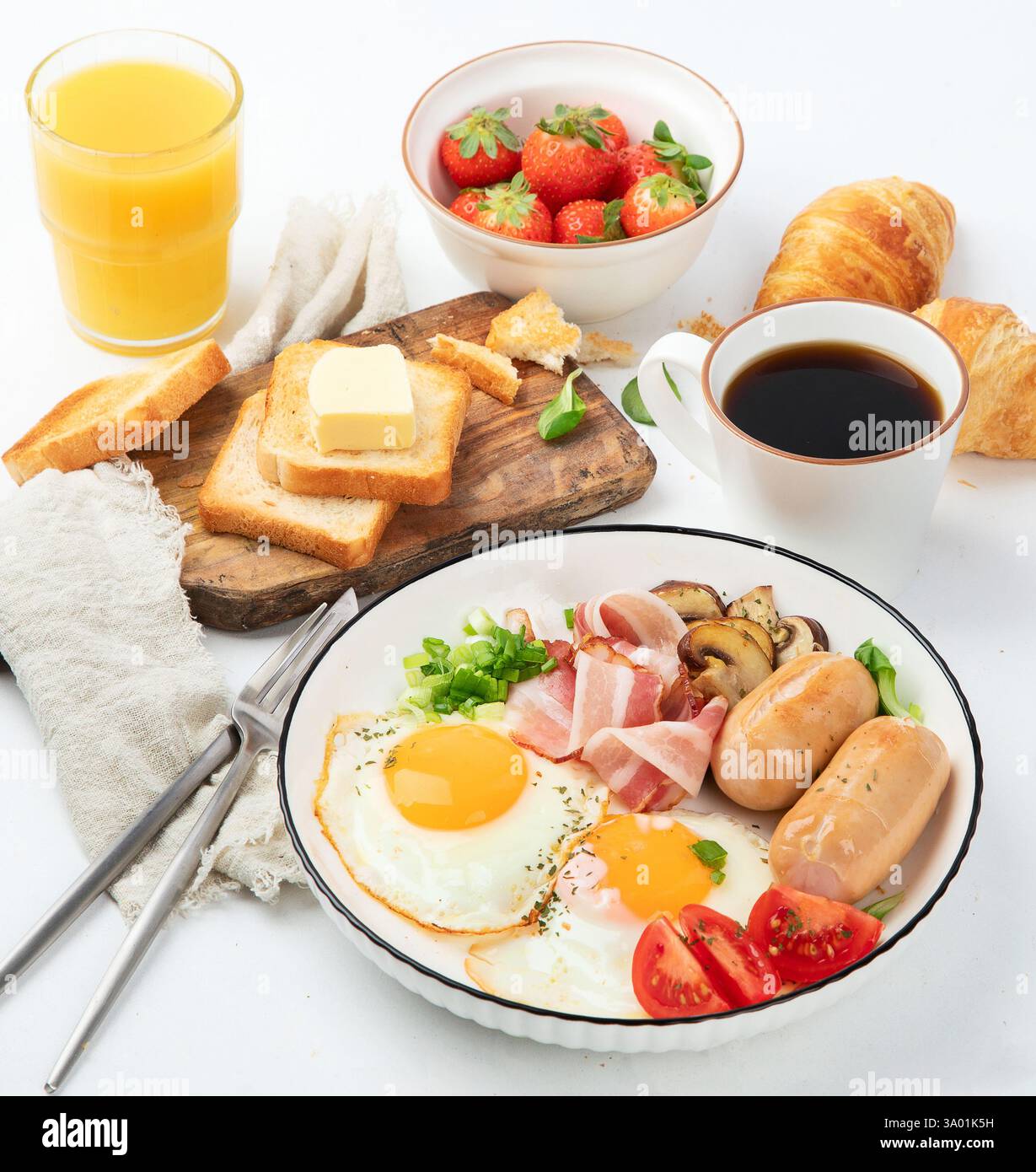 Colazione all'inglese con uova fritte, salsiccia, pancetta e pane tostato Foto Stock