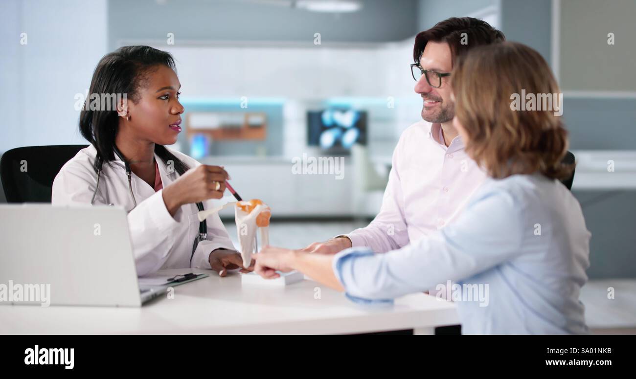 Chirurgo ortopedico afroamericano che cura pazienti con dolore articolare alla spalla in ospedale. Foto Stock