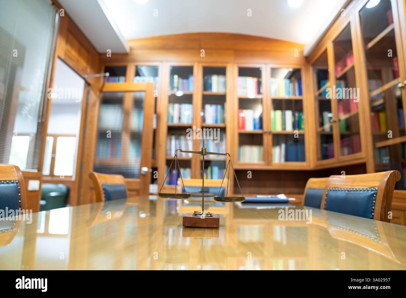 La vecchia scala di legge di Ottone è in stile vintage su un tavolo di vetro di legno nella sala riunioni dell'ufficio di Lawyer. Foto Stock