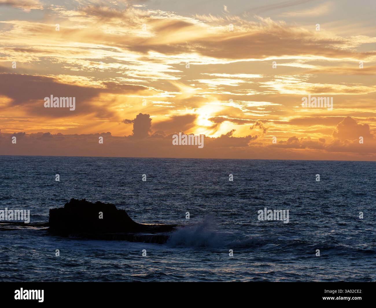 Le onde si infrangono su una formazione rocciosa al tramonto a Essaouria, in Marocco. Febbraio/marzo 2025 Foto Stock