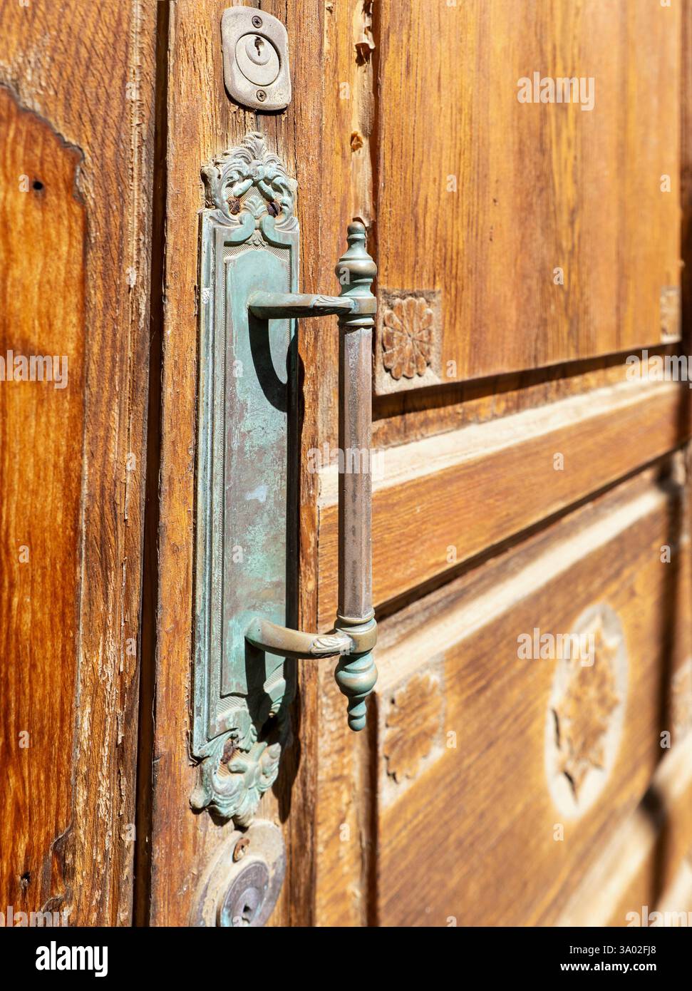 Primo piano di una vecchia maniglia ossidata su una porta d'ingresso storica. Foto Stock