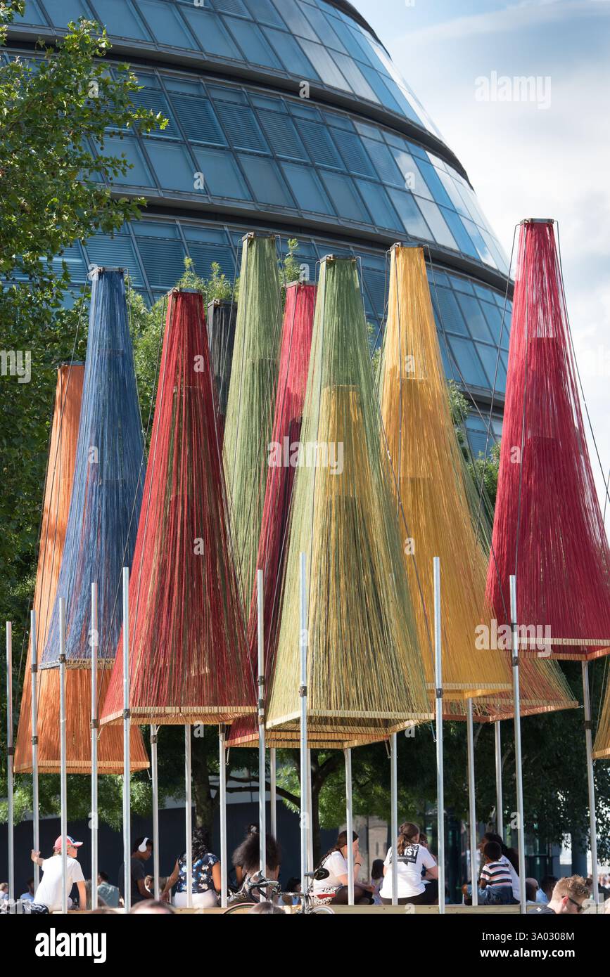 Di fronte al Municipio di Londra sono allestite strutture colorate con fili, probabilmente posti a sedere pubblici temporanei. Le persone si rilassano sotto le tettoie colorate. Foto Stock
