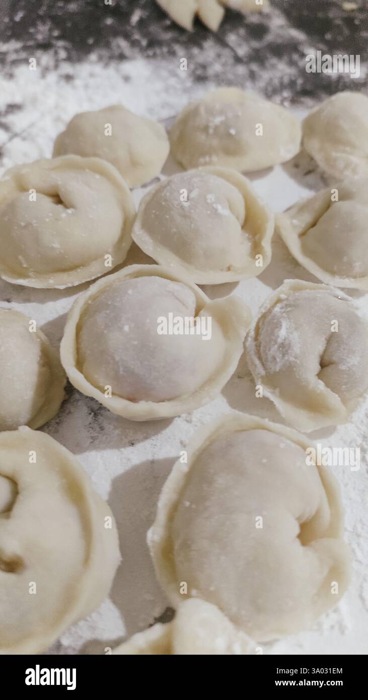 Gnocchi russi fatti a mano, produzione. I gnocchi crudi sono stati collocati su un tavolo da cucina in legno. Foto Stock
