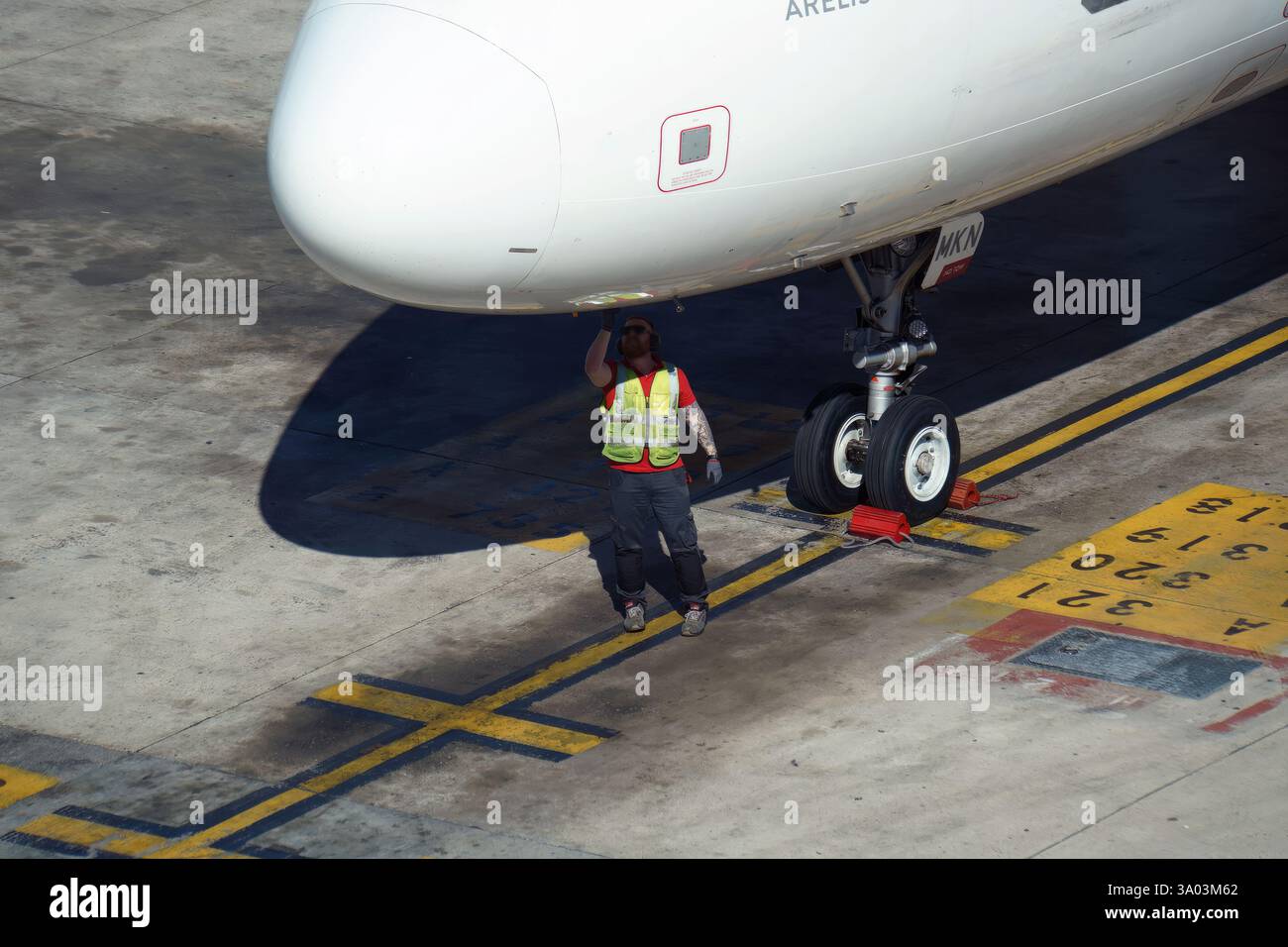 Equipaggio di terra lato volo che prepara gli aeromobili parcheggiati sul piazzale del terminal per la partenza. Foto Stock