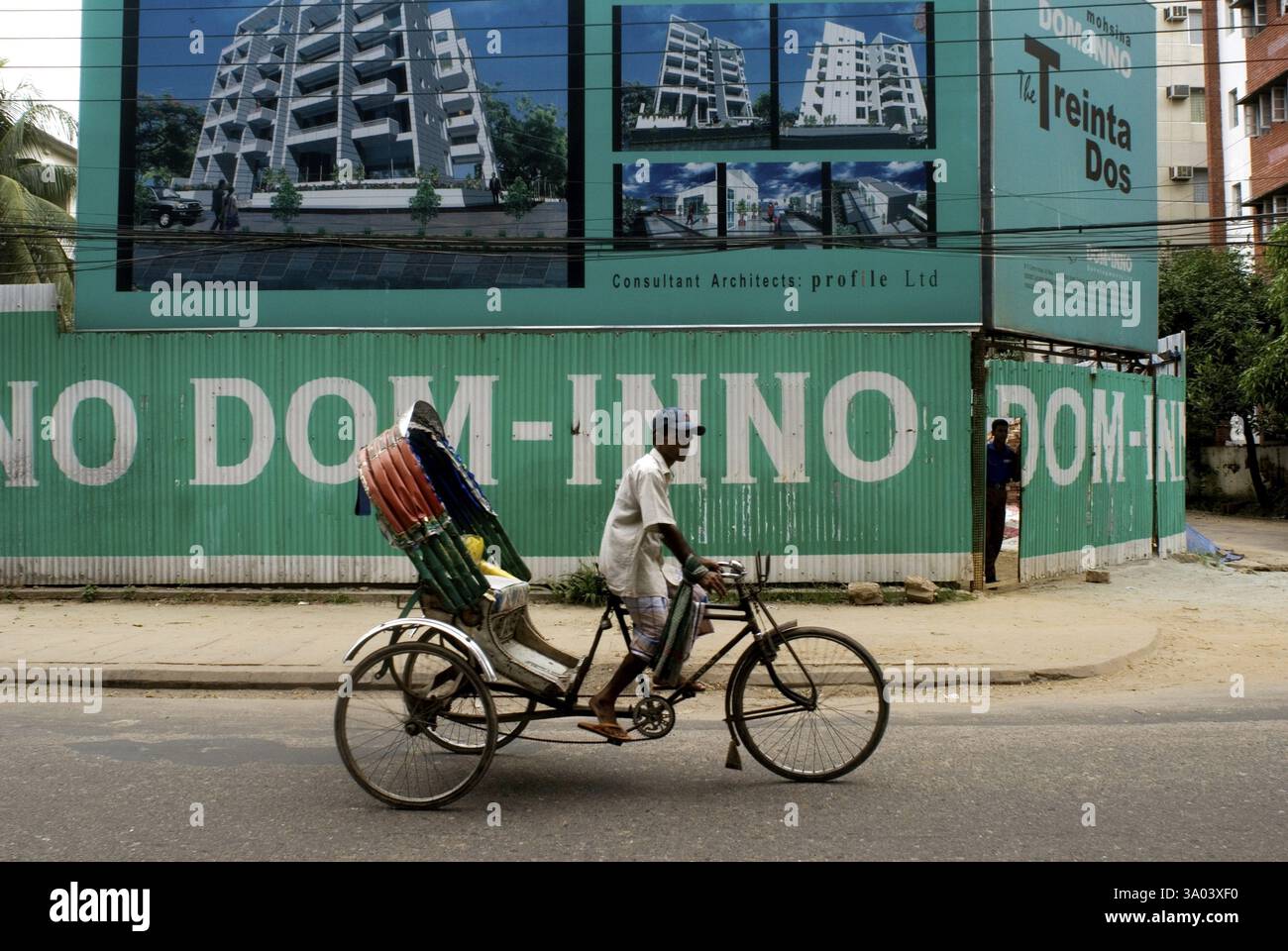 Pedala con Rickshaw Rider a bordo del suo veicolo vuoto per strada, Dacca, Bangladesh, Asia Foto Stock