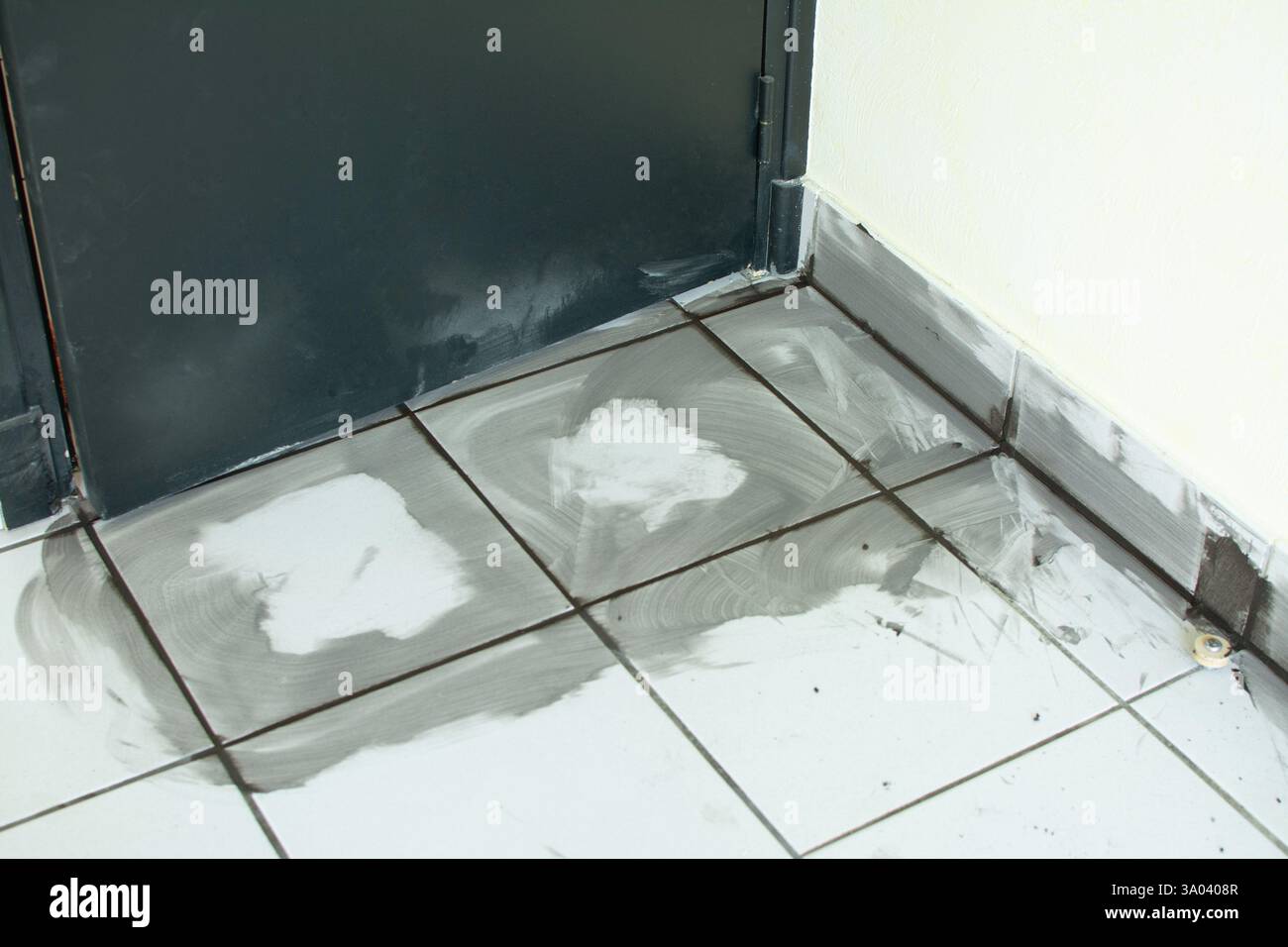 Fissaggio di piastrelle danneggiate in uno spazio commerciale prima della riapertura Foto Stock