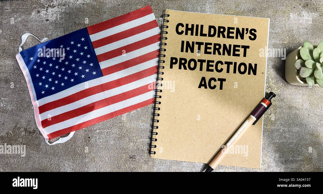 Concetto di Children's Internet Protection Act scrivere sul libro e Flag of the United States Isolated on Wooden Table. Foto Stock