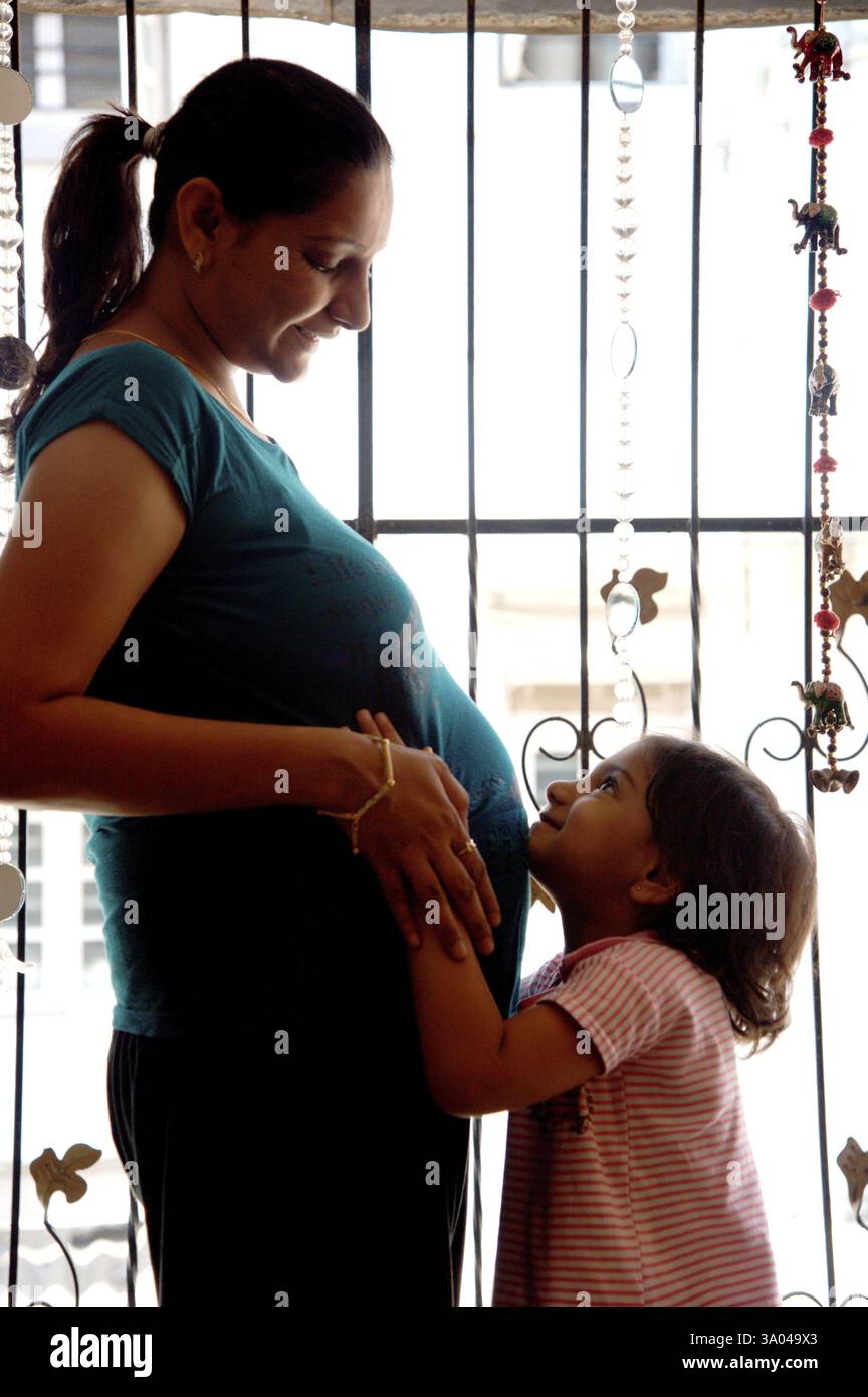 Indiano incinta madre coda di pony bambino mento che tocca lo stomaco, India, Asia, MR#736K, MR#736L, Asia Foto Stock