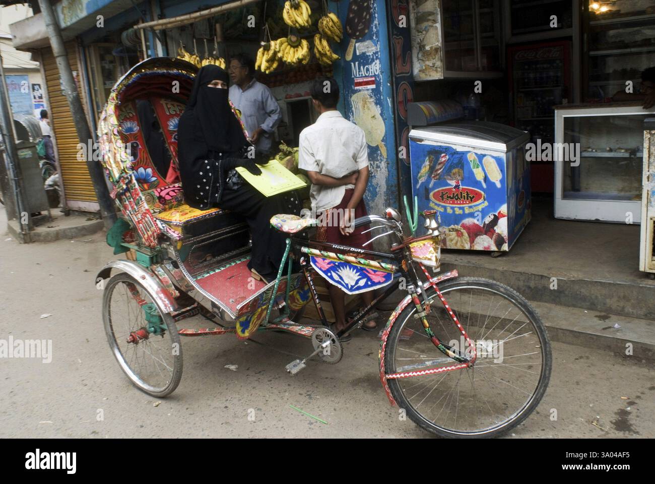 Donna seduta a Cycle Rickshaw e in attesa di Rider per strada a Dhaka, Bangladesh, Asia Foto Stock