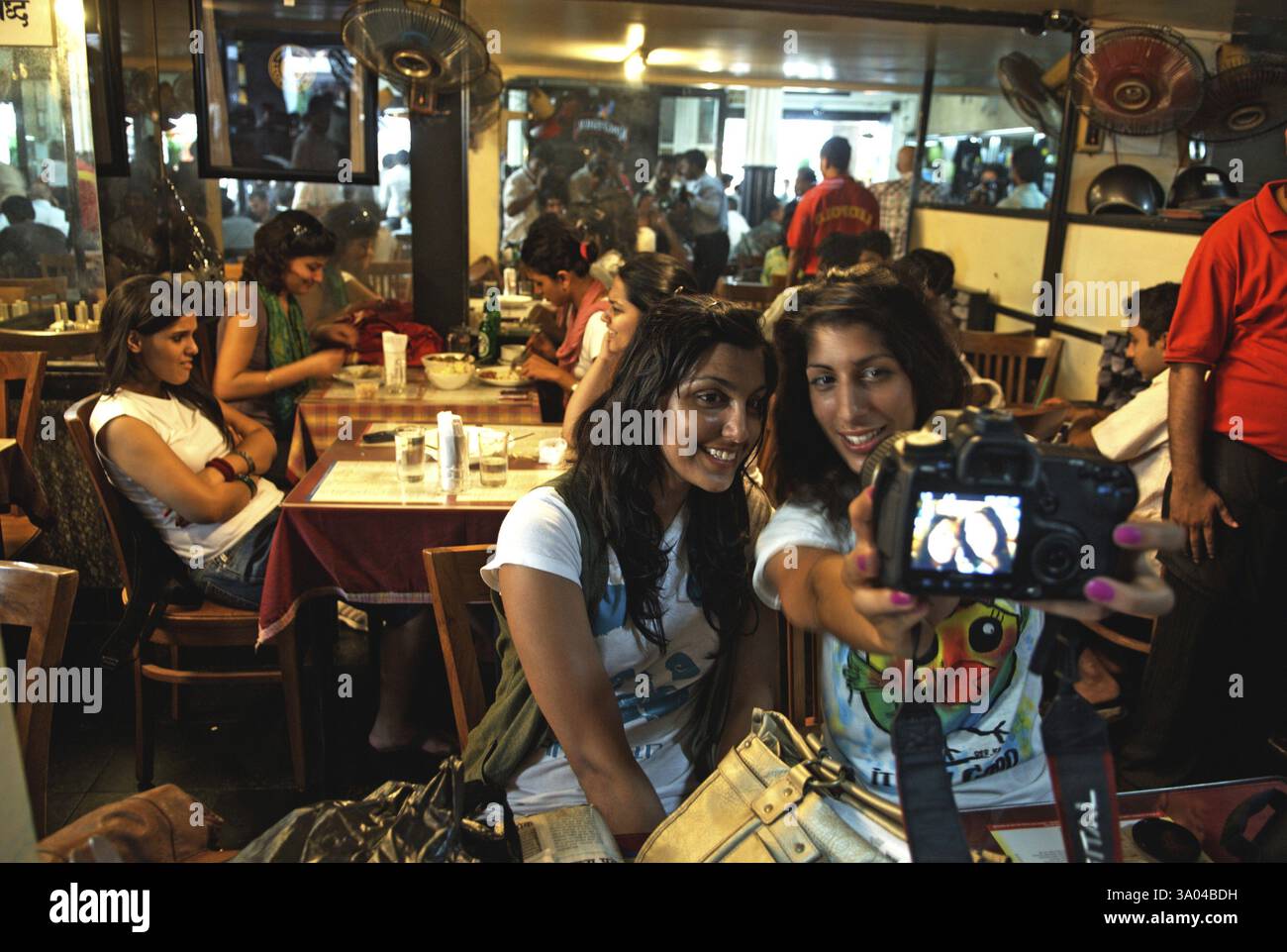 I visitatori si fanno fotografare al Cafe leopold di colaba dopo l'attacco terroristico dei mujaheddin del deccan a Bombay Mumbai Foto Stock