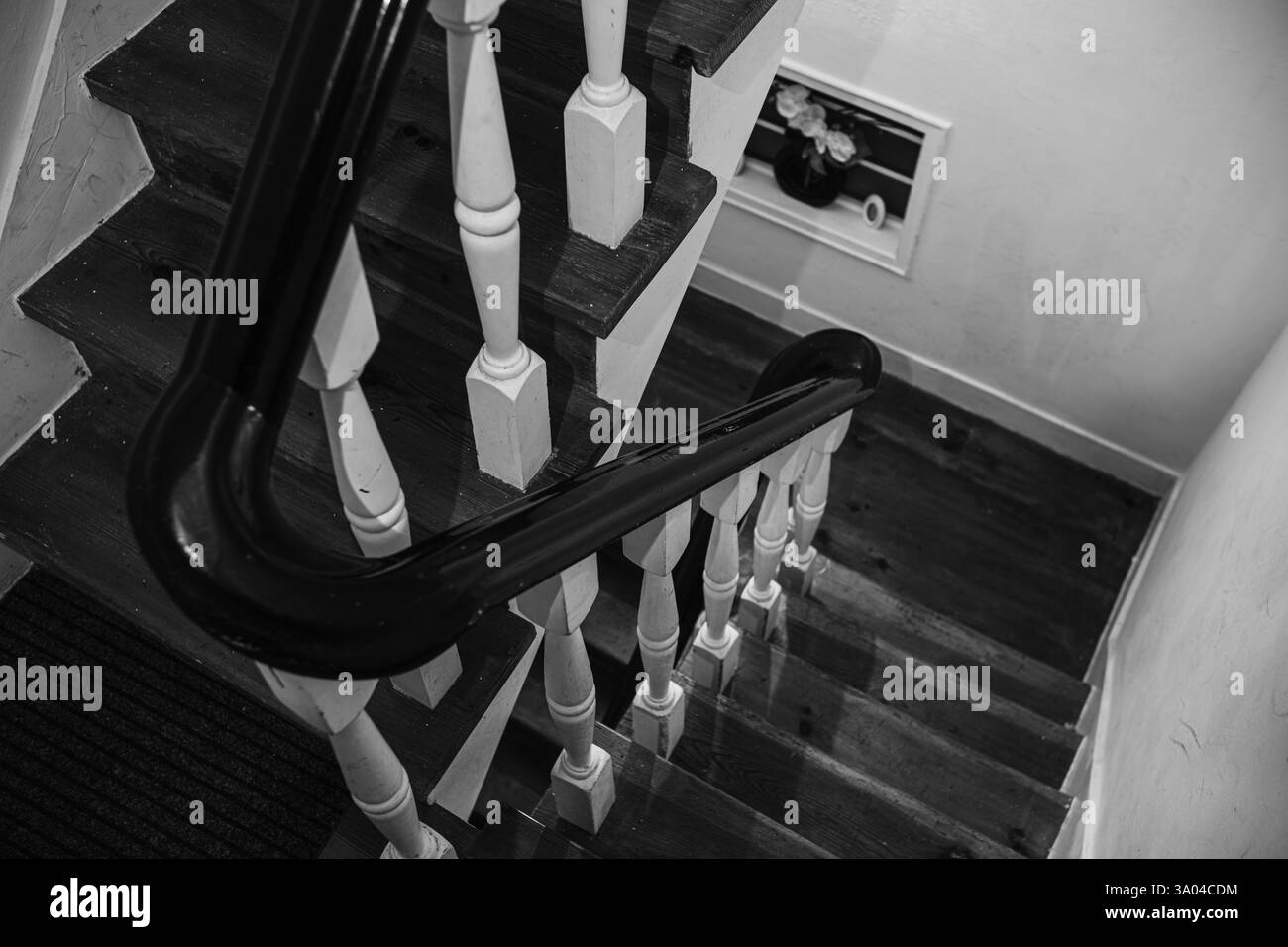 Gradini in una vecchia casa fatta di legno e ringhiere dipinte in bianco e nero. Scala in una vecchia casa europea a più piani. Splendida immagine di sfondo. Foto Stock