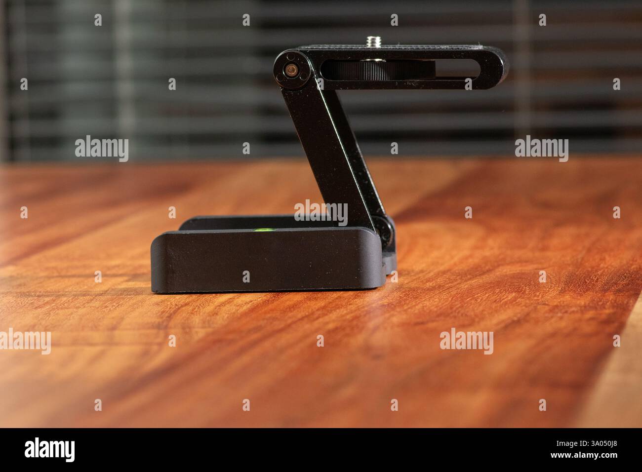 Immagine ravvicinata che mostra un supporto compatto regolabile per fotocamera su una superficie in legno chiaro. Foto Stock