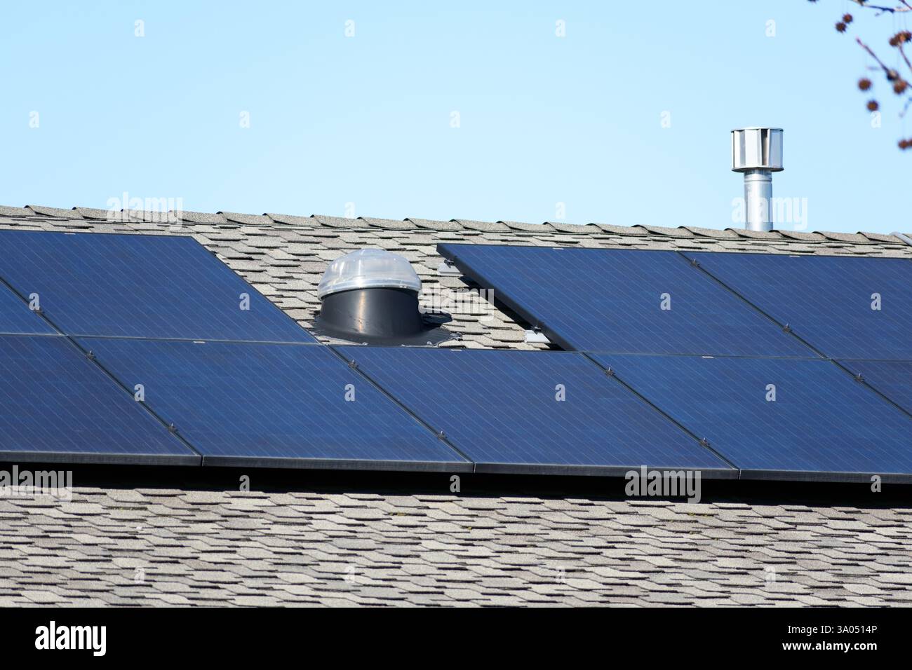 Pannelli solari installati su un tetto a baldacchino con una cupola lucernario e un tubo di ventilazione in metallo. Foto Stock