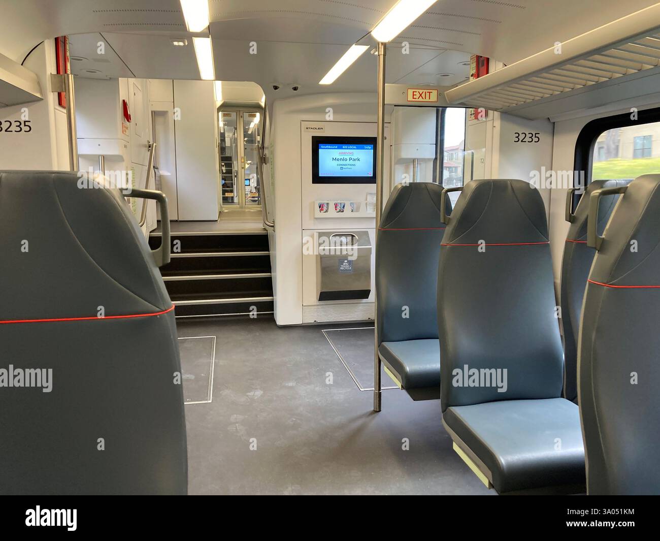 Interno di un vagone ferroviario Caltrain con sedili a gradini, una scala che porta ad un altro livello e un display digitale di informazioni vicino all'ingresso - Menlo Park Foto Stock