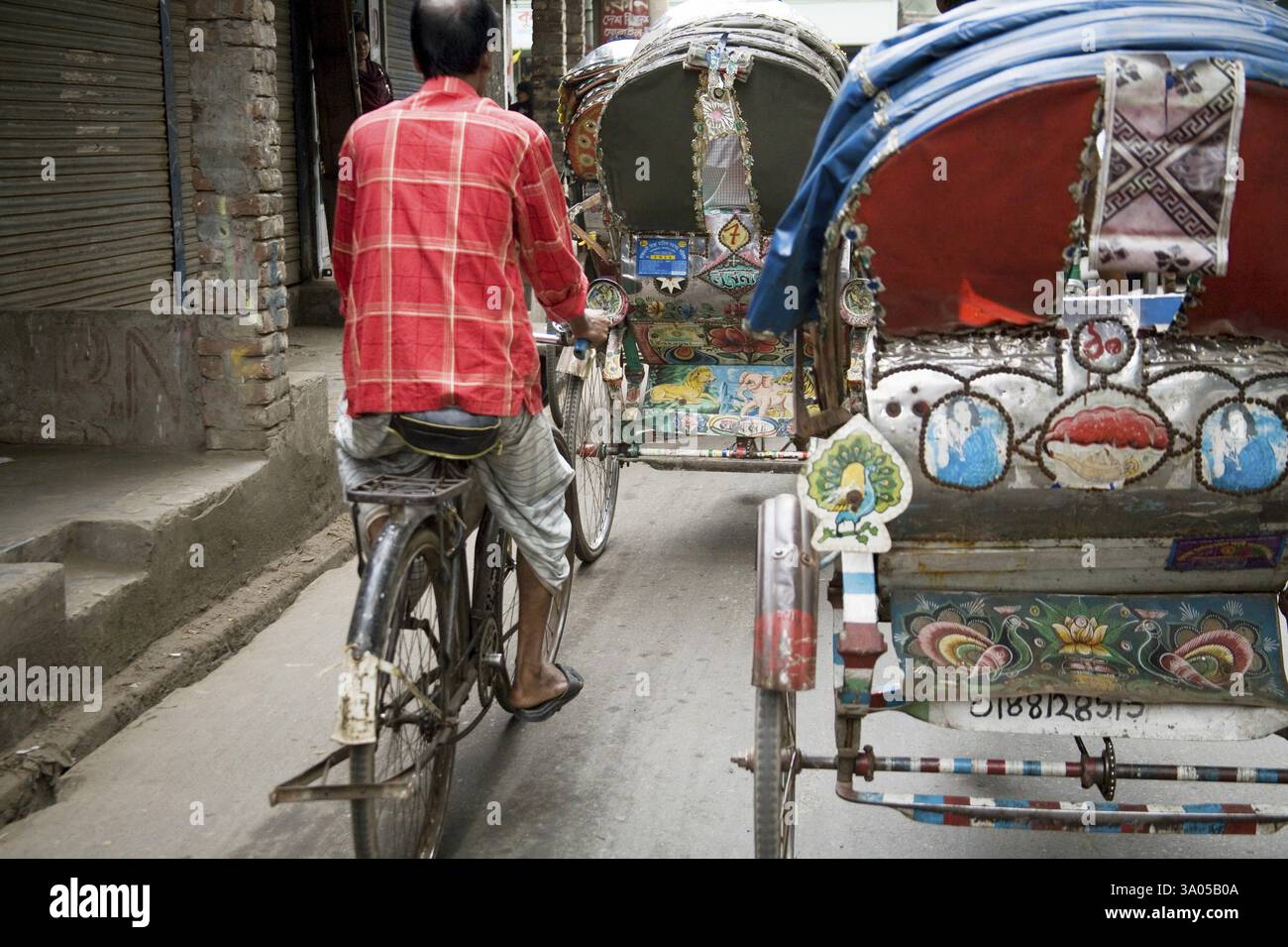 Pedala in risciò e in bicicletta su strada, nella vecchia Dacca, in Bangladesh, in Asia Foto Stock
