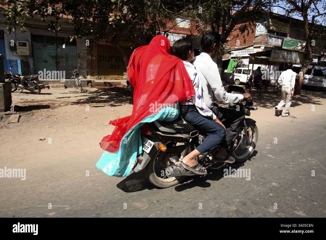 Tre membri della famiglia che viaggiano su un motociclo a due ruote nella città di Ahmedabad, Gujarat, India, Asia Foto Stock