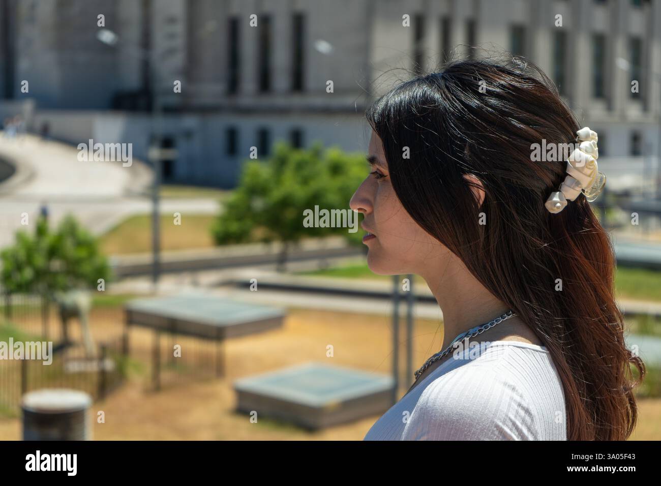 Vista laterale di un'elegante donna latina che contempla la vista urbana di buenos aires, argentina, che mostra eleganza e apprezzamento culturale Foto Stock
