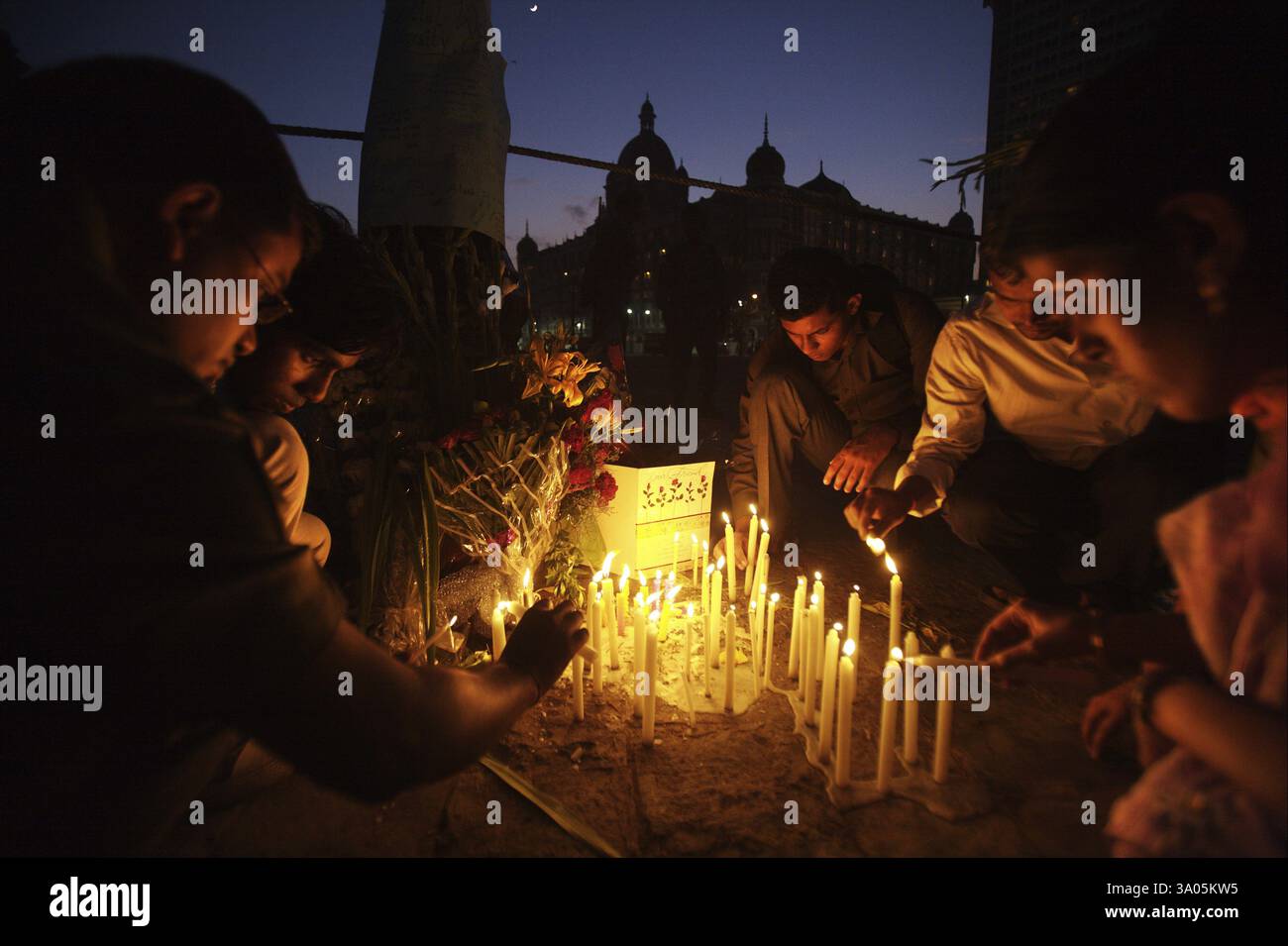 Persone accendendo candele al gateway in omaggio alle vittime di attacchi terroristici Deccan Mujahedeen il 26 novembre 2008 a Bombay Foto Stock
