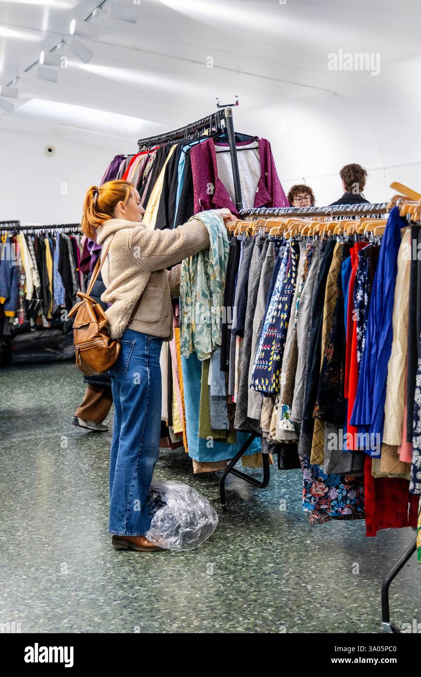 Donna che naviga alla vendita di chilo di abbigliamento vintage presso l'Ecology Pavilion di Mile End (vale la pena la vendita di peso), Londra, Inghilterra Foto Stock Donna che naviga alla vendita di chilo di abbigliamento vintage presso l'Ecology Pavilion di Mile End (vale la pena la vendita di peso), Londra, Inghilterra Foto Stock